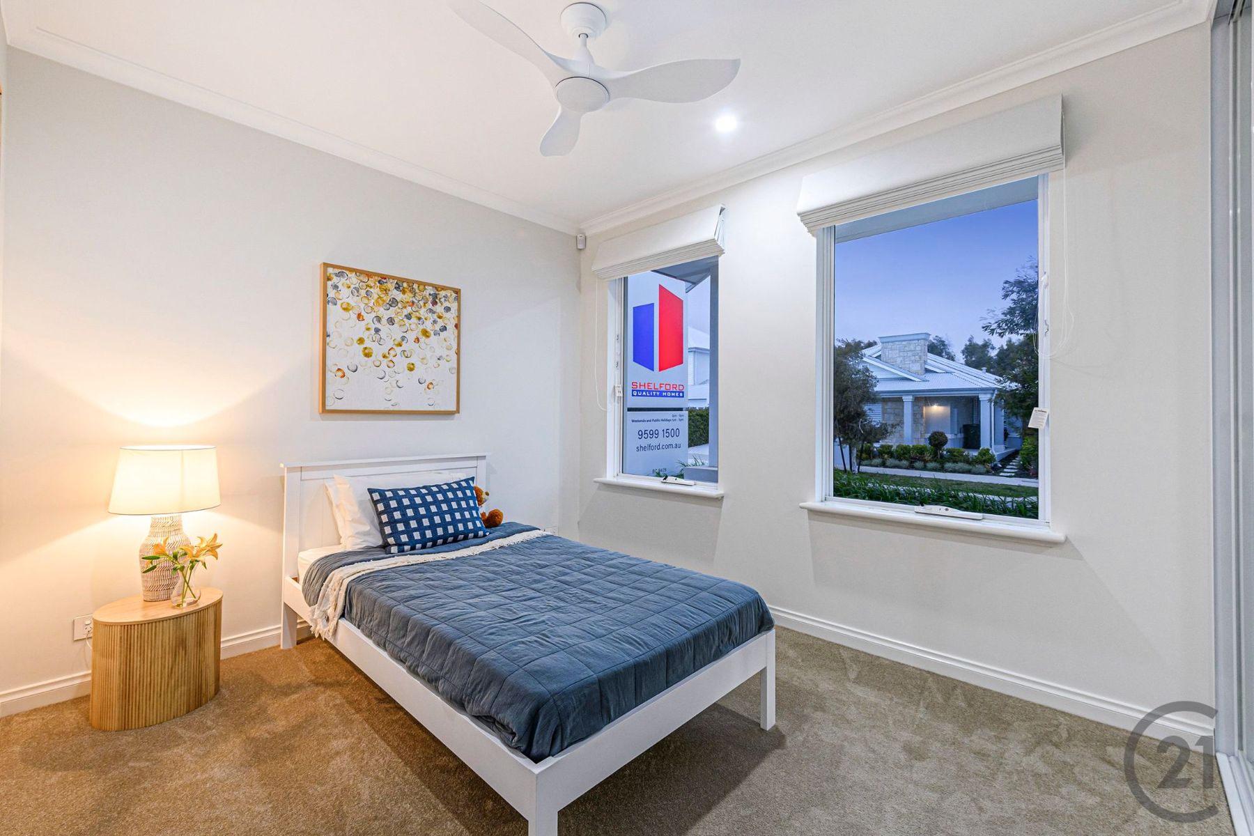 Bedroom with single bed, ceiling fan and two street-facing windows