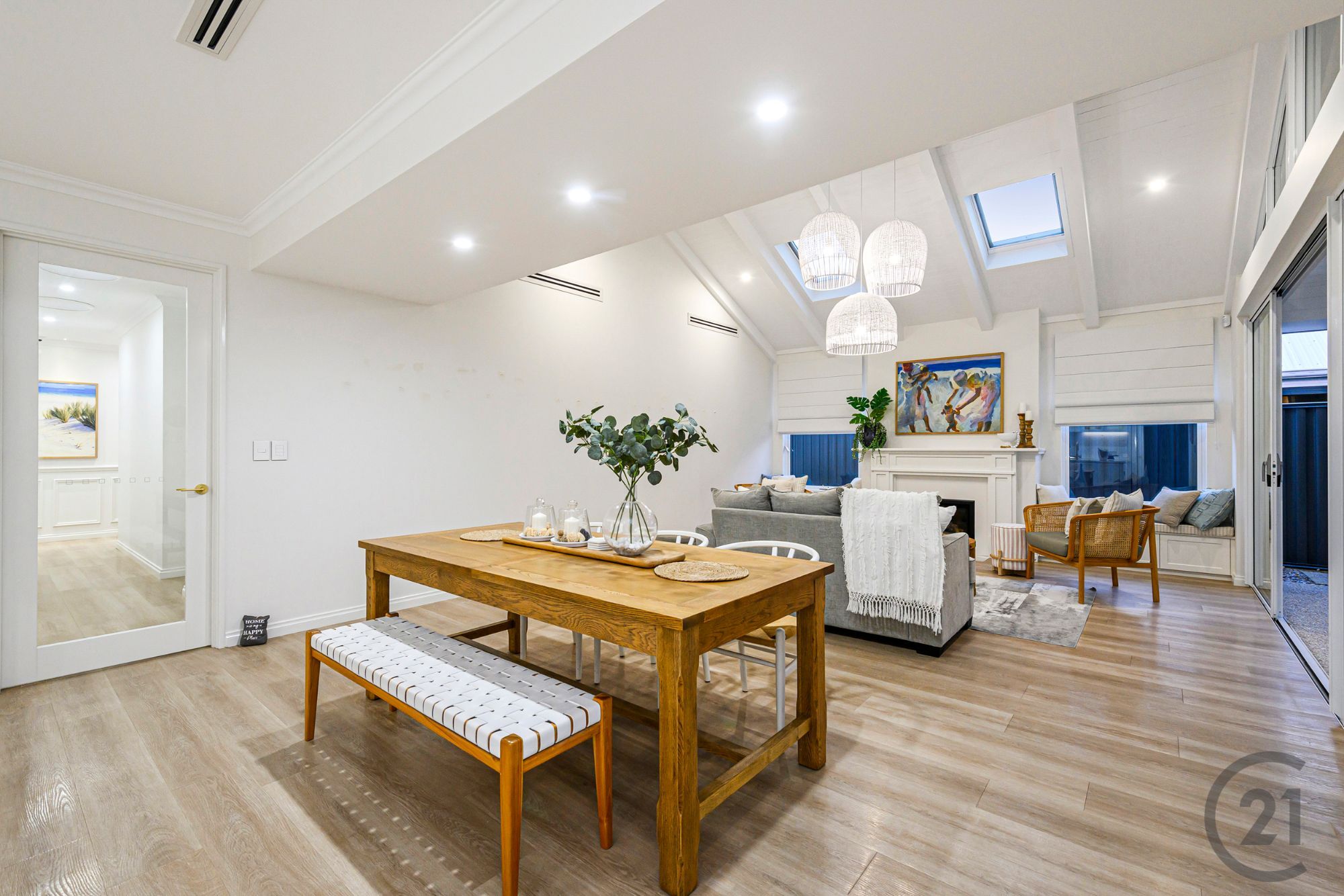 Dining table under the raked ceiling, looking to the fireplace and living area