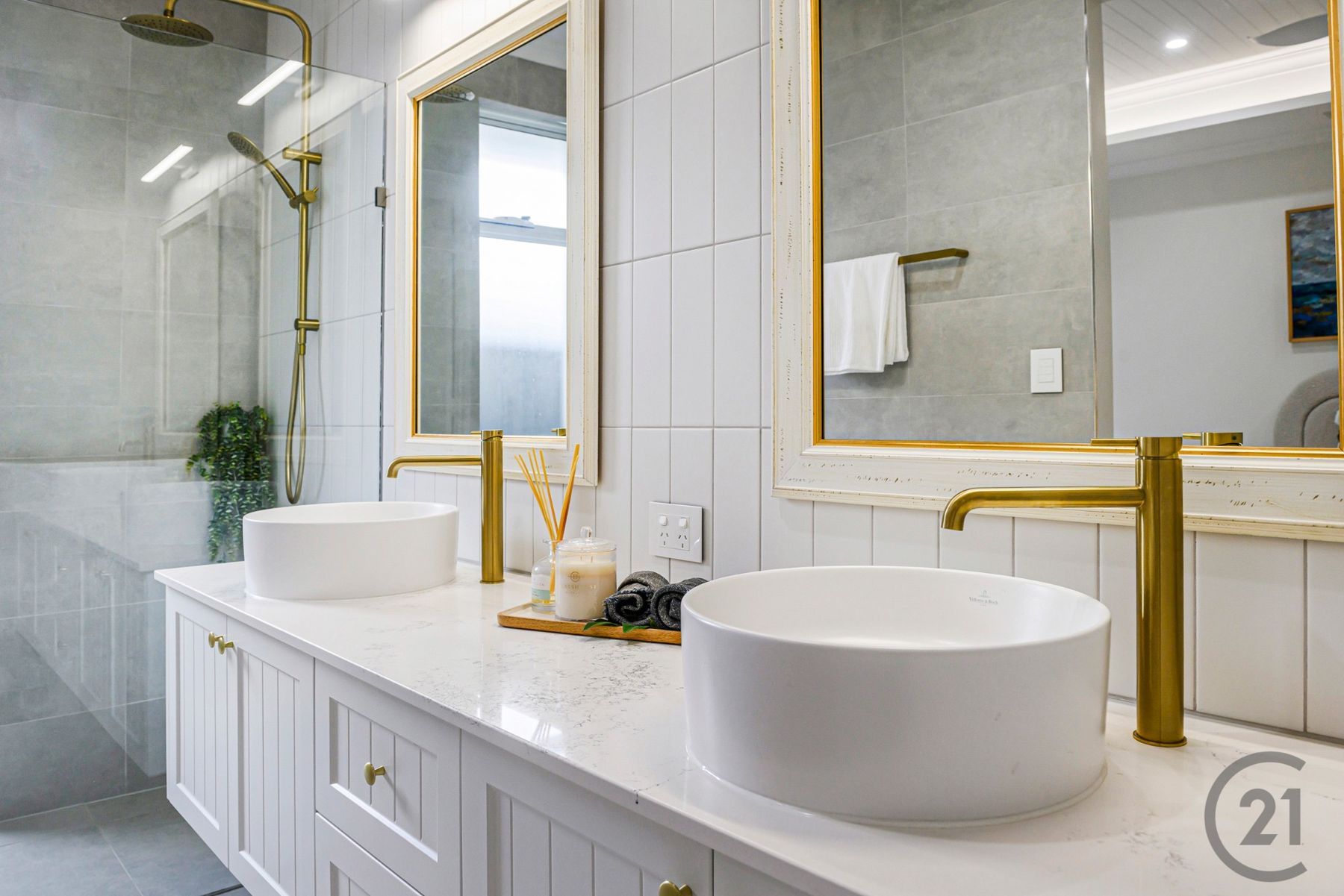 Close view of the ensuite twin vessel basins and brushed brass tapware