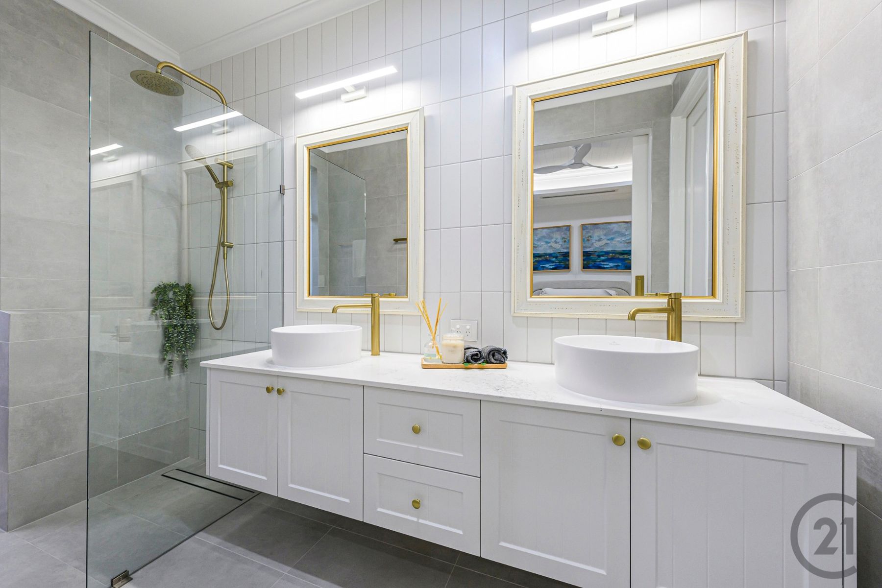 Ensuite with floating white double vanity, vessel basins, gold mirrors and walk-in shower