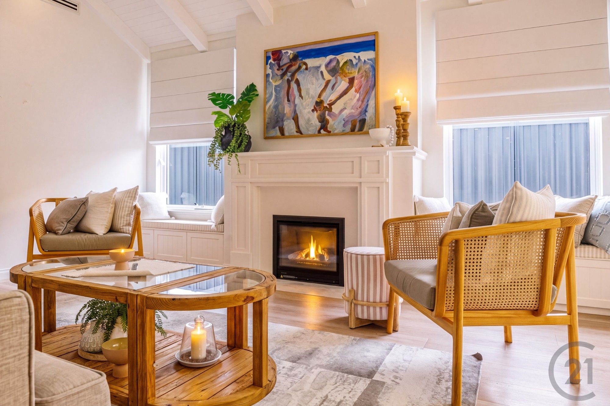 Gas fireplace with white mantel, window seats and rattan armchairs