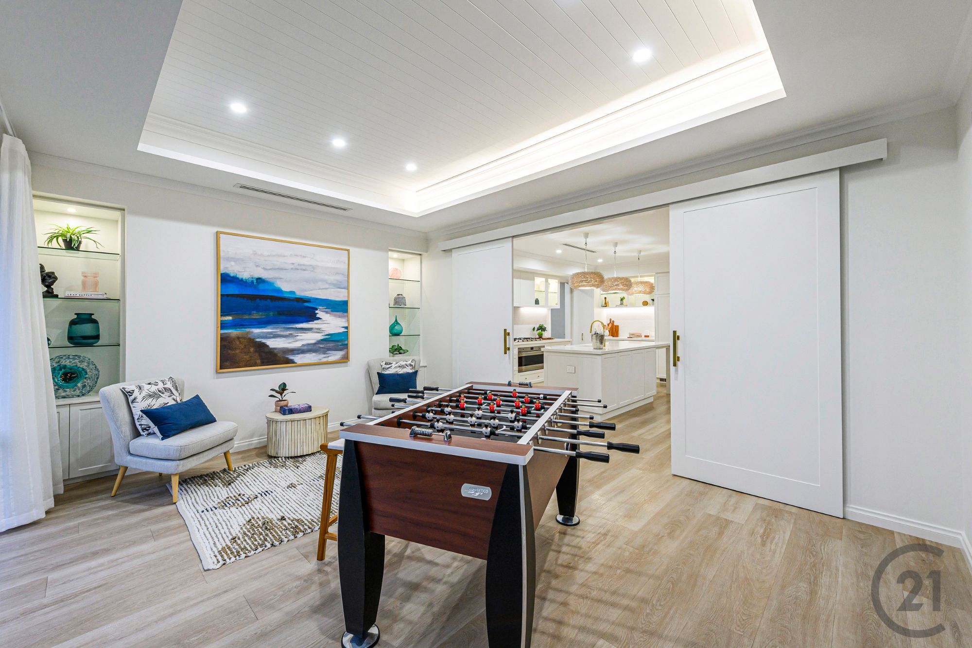 Games room with cove-lit ceiling, display niches and sliding doors to the kitchen