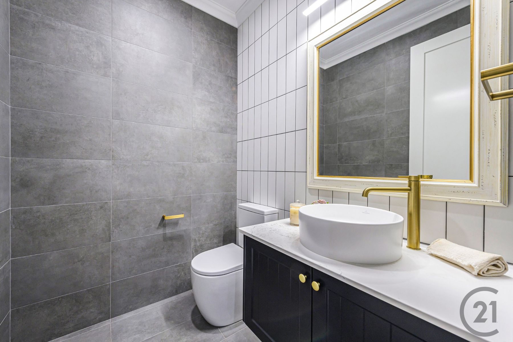 Powder room with charcoal vanity, vessel basin and brass tapware