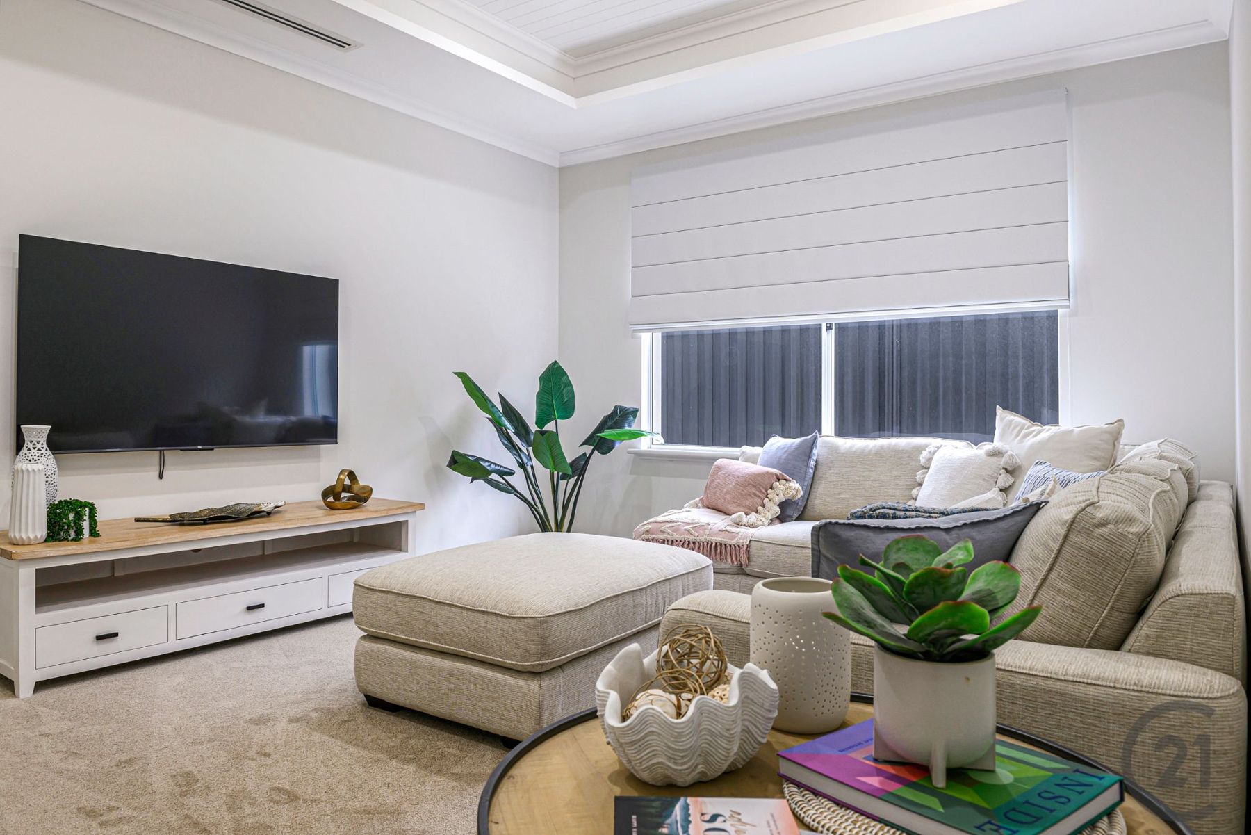 Home theatre from the sofa, with wall-mounted TV and roman blind