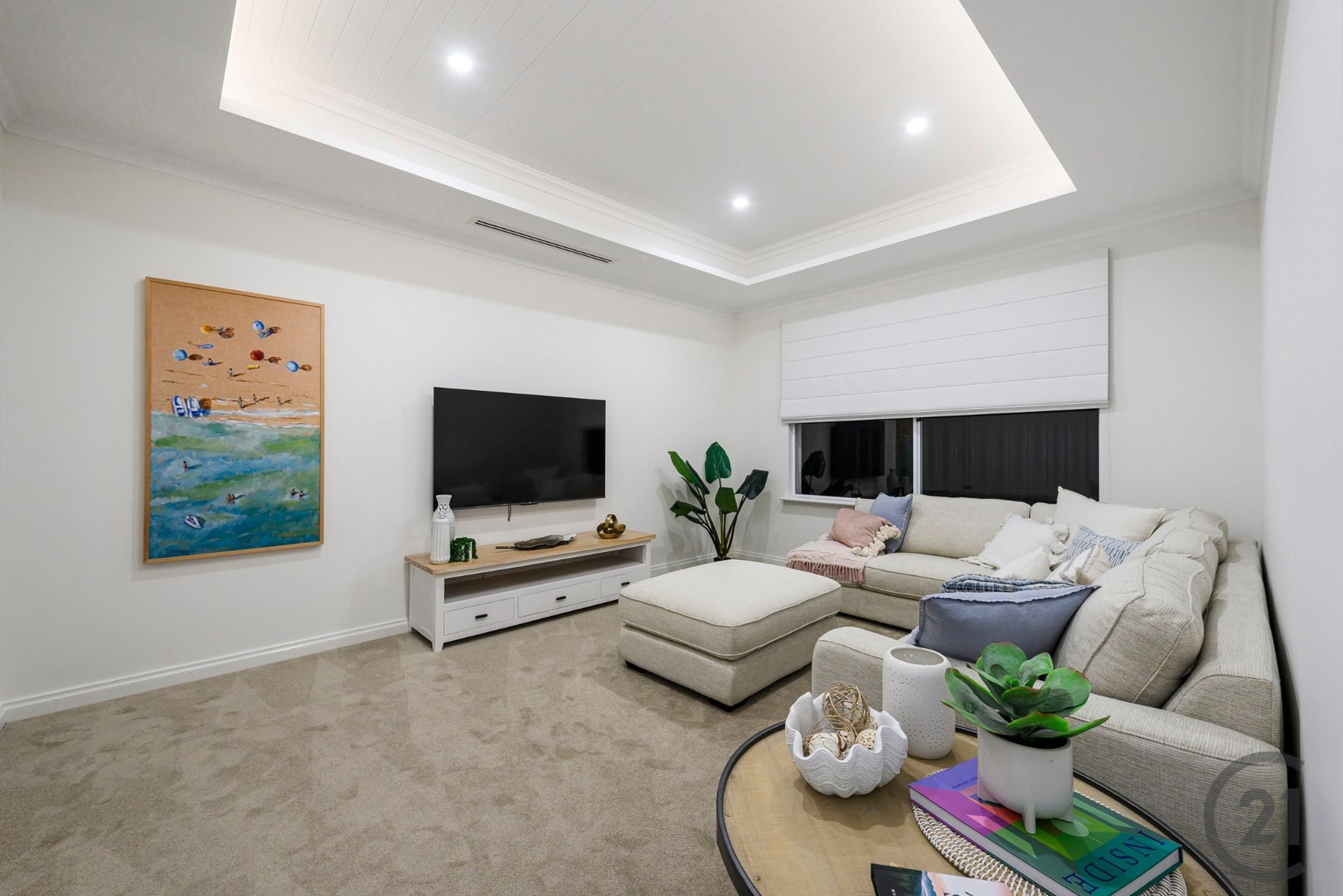 Theatre room with recessed lined ceiling, modular sofa and wall-mounted TV